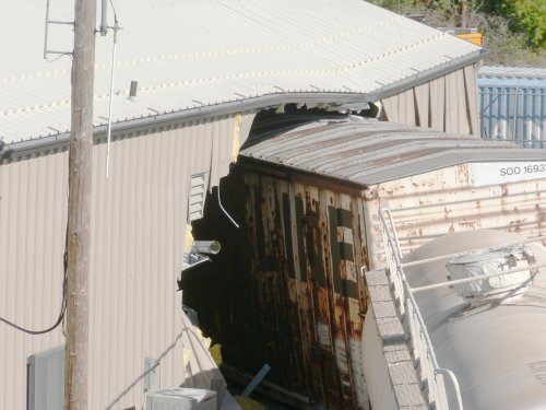 A closeup of the box car and tank which penetrated the office building.